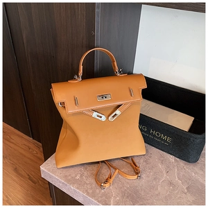 Detail view of a brown faux leather convertible backpack on a marble surface