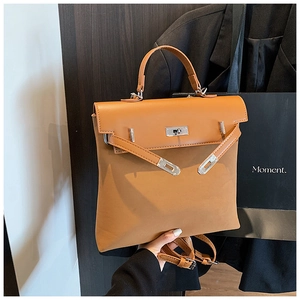Detail of a brown Kelly-style handbag with a silver twist lock and smooth faux leather finish
