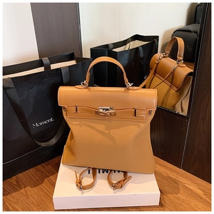 Caramel vintage backpack with Kelly lock detail shown in a high-end luxury display setting