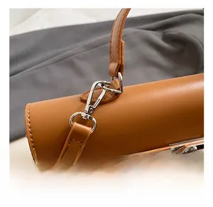 Detail of silver metal lobster clasp and premium brown leather texture on handbag
