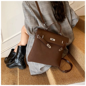Detail of vintage dark brown leather backpack with silver metallic twist lock and strap