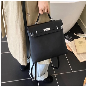Detail of black matte dual-use backpack featuring a silver Kelly buckle and top handle