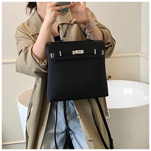 Detail showing back straps of a black textured leather convertible backpack with silver clasp