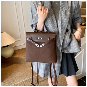 Detail of deep brown matte leather backpack with vintage metal twist lock on stairs