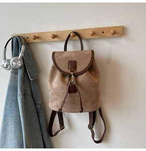 Detail of vintage drawstring backpack in camel suede and brown leather trim on hook