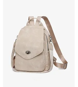 Detail of cream leather backpack featuring metal twist lock and geometric woven strap