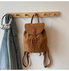 Detail of vintage brown frosted leather backpack with flap closure and drawstring design