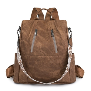 Front view of a brown patterned backpack with dual zippers and a geometric strap