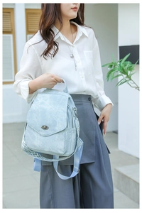 Light blue faux leather backpack with vintage texture and geometric pattern shoulder strap