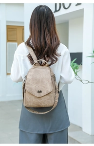 Detail of soft leather backpack with woven geometric shoulder strap and metal twist lock