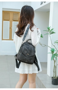 Detail of dark grey vintage leather backpack with geometric pattern shoulder strap