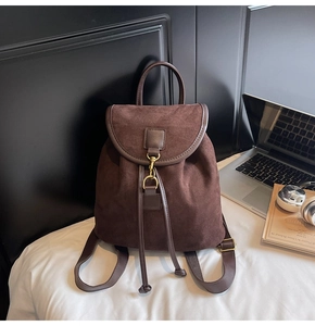 Macro shot of dark brown frosted leather backpack with vintage metal hook and drawstring