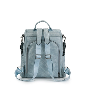 Detail view of adjustable straps and zipper pockets on the light blue vintage backpack
