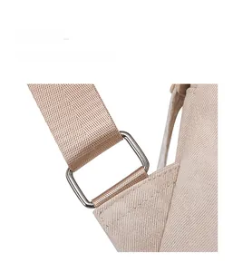 Detail of reinforced shoulder strap connection with durable metal buckle on beige backpack