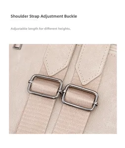 Close-up of adjustable metal buckle on beige fabric backpack shoulder strap