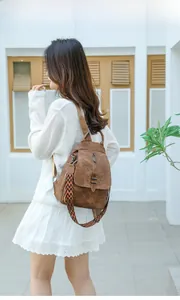 Detailed view of brown PU leather backpack with vintage ethnic geometric shoulder strap