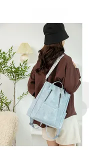 Detail view of light blue backpack with stylish geometric strap in a cozy home setting