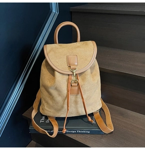 Detailed shot of camel suede backpack featuring drawstring closure and metal spring hook