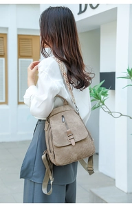Close-up of brown PU leather backpack featuring ethnic style geometric woven straps