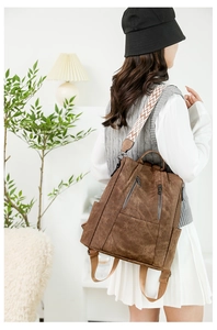 Brown faux suede backpack featuring a colorful geometric patterned wide strap detail