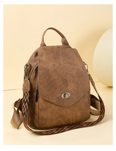 Close-up of vintage brown backpack featuring a geometric woven strap and metal twist lock