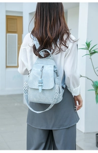 Detail of light blue PU leather backpack featuring a geometric pattern woven wide strap