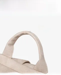 Detail of the soft beige canvas handle with reinforced stitching for comfortable grip