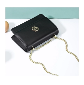 Détail du sac à bandoulière en cuir noir avec chaîne dorée et logo métallique entrelacé