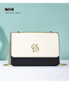 Vue détaillée du sac bicolore blanc cassé et noir avec chaîne dorée et fermoir rond