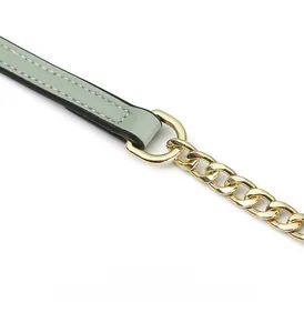 Détail de la bandoulière en cuir vert menthe avec surpiqûres blanches et chaîne dorée