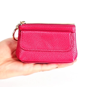 Detail of rose red lychee grain leather coin purse with golden zipper and key ring