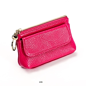 Side view of rose red leather coin purse with zipper and heart keychain attachment