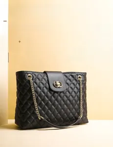 Detail der klassischen schwarzen gesteppten Ledertasche mit goldener Schließe und Kette