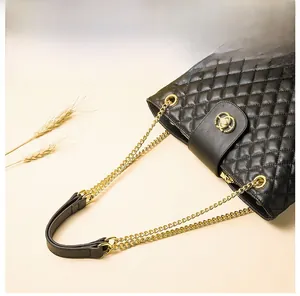 Detail einer schwarzen Stepptasche aus Leder mit goldener Kette und Metallverschluss