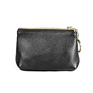 Detail of black lychee leather coin purse with gold zipper and round key ring attachment