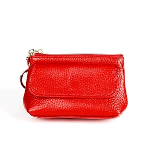 Detail of red pebbled leather coin purse featuring a gold zipper and magnetic flap pocket