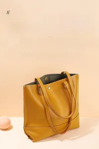 Détail d'un sac cabas en cuir jaune avec texture grainée et coutures blanches