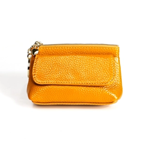 Detail of yellow pebbled leather coin purse featuring a golden heart zipper charm