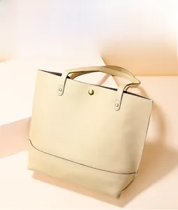 Détail d'un cabas en cuir grainé crème avec fermoir magnétique doré et doubles poignées