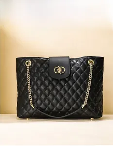 Details der schwarzen Stepptasche mit goldener Schließe und Ketten-Schultergurt