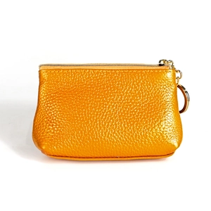 Close-up of orange pebble grain leather coin purse with golden zipper and key ring