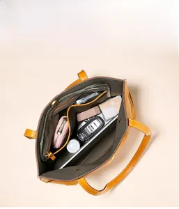 Vue de dessus montrant l'intérieur spacieux et les compartiments du sac cabas en cuir jaune