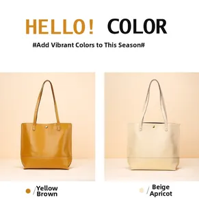 Détail de cabas en cuir jaune-brun et beige-abricot avec poignées fines et clous métalliques
