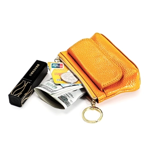 Macro view of bright yellow litchi grain leather coin purse with golden hardware and key ring