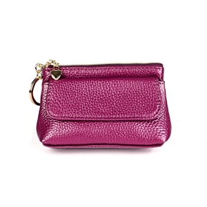 Macro shot of rose red lychee grain leather purse with golden heart pendant and hardware