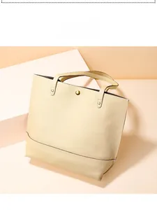Détail du sac cabas en cuir grainé crème avec fermoir magnétique doré et rivets