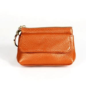 Detail of orange pebble leather coin purse with gold zipper and heart pendant