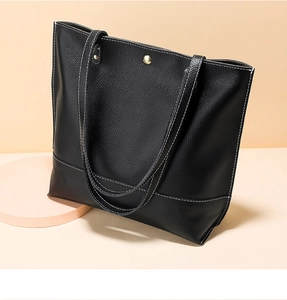 Détail du cabas en cuir noir avec surpiqûres blanches et fermoir magnétique doré brillant