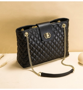 Details der schwarzen gesteppten Ledertasche mit goldener Metallkette und Rautenmuster