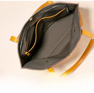 Vue intérieure du cabas en cuir jaune montrant la grande capacité et la poche zippée